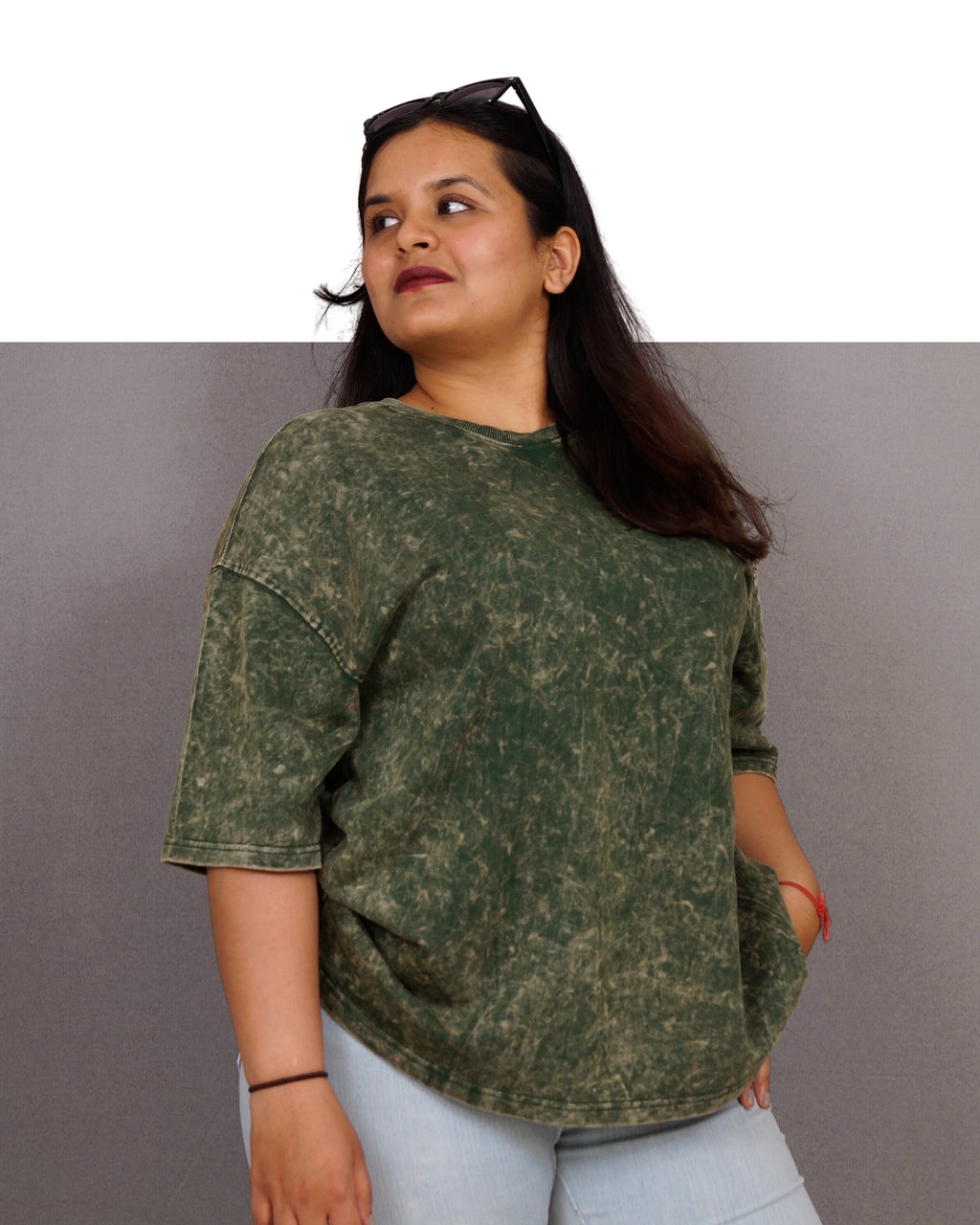 Woman wearing a green camouflage shirt against a gray background