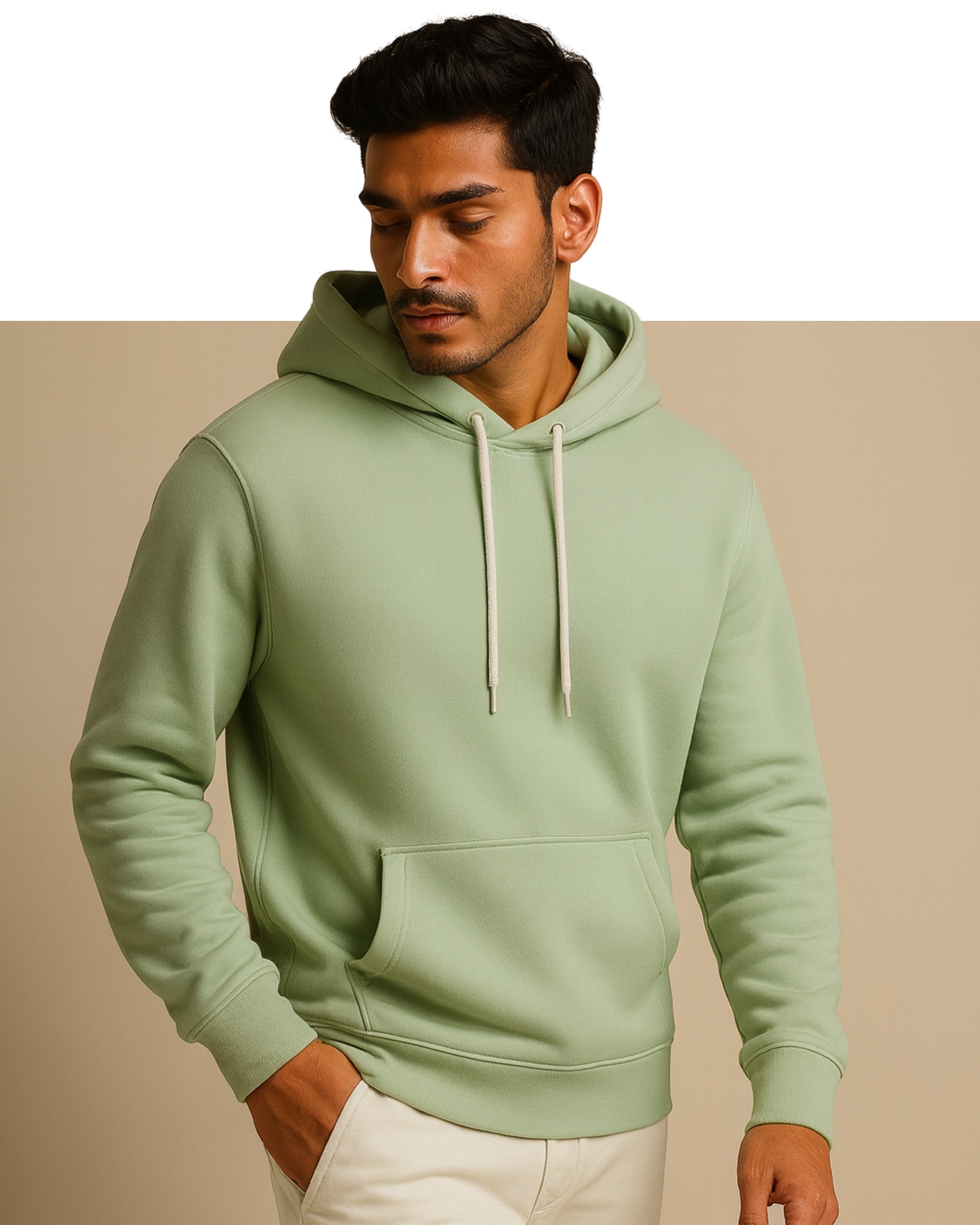 Man wearing a light green hoodie against a beige background