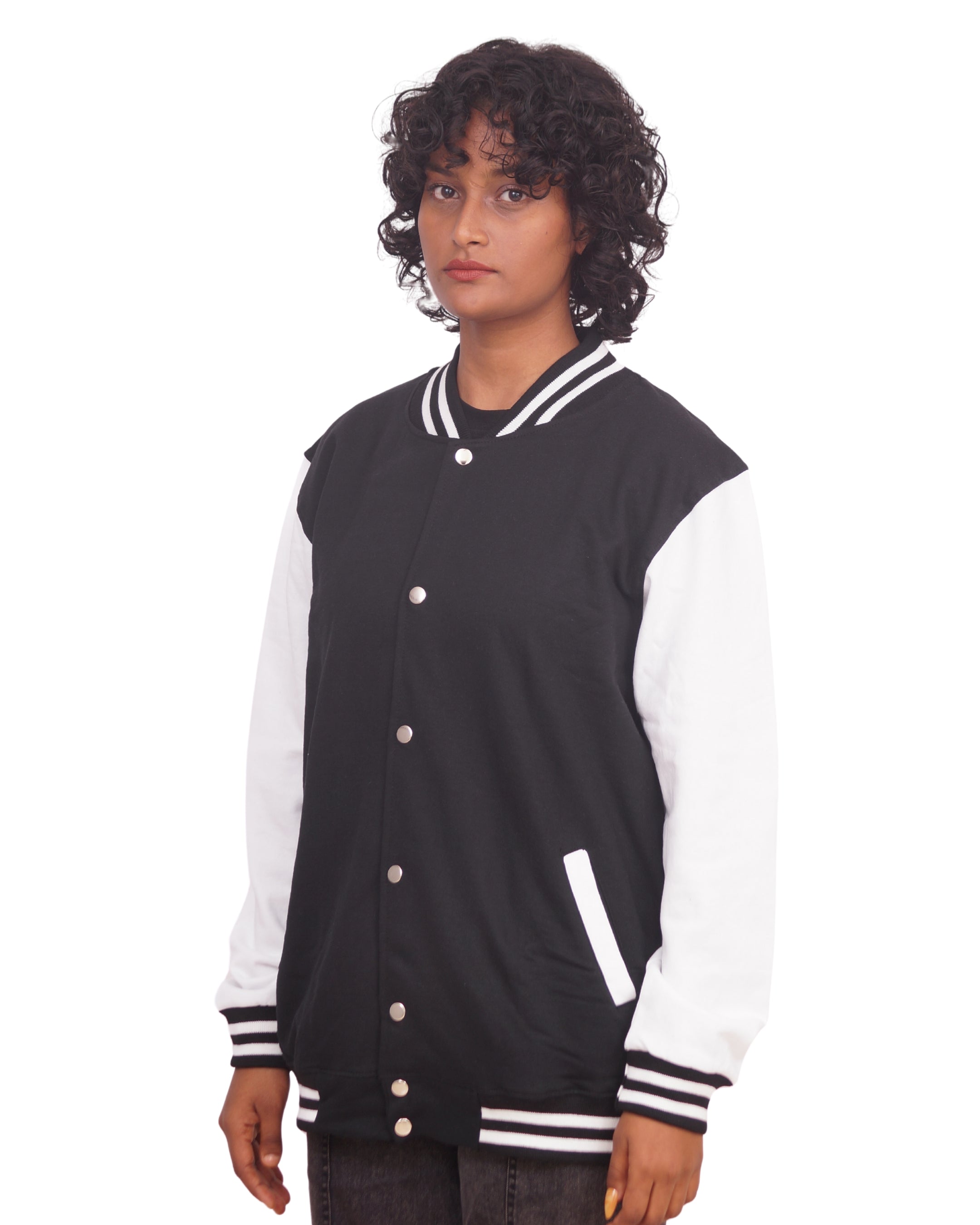 Person wearing a black and white varsity jacket on a white background