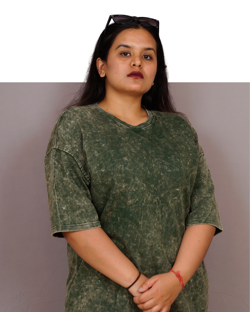 Woman wearing a green patterned shirt against a plain background