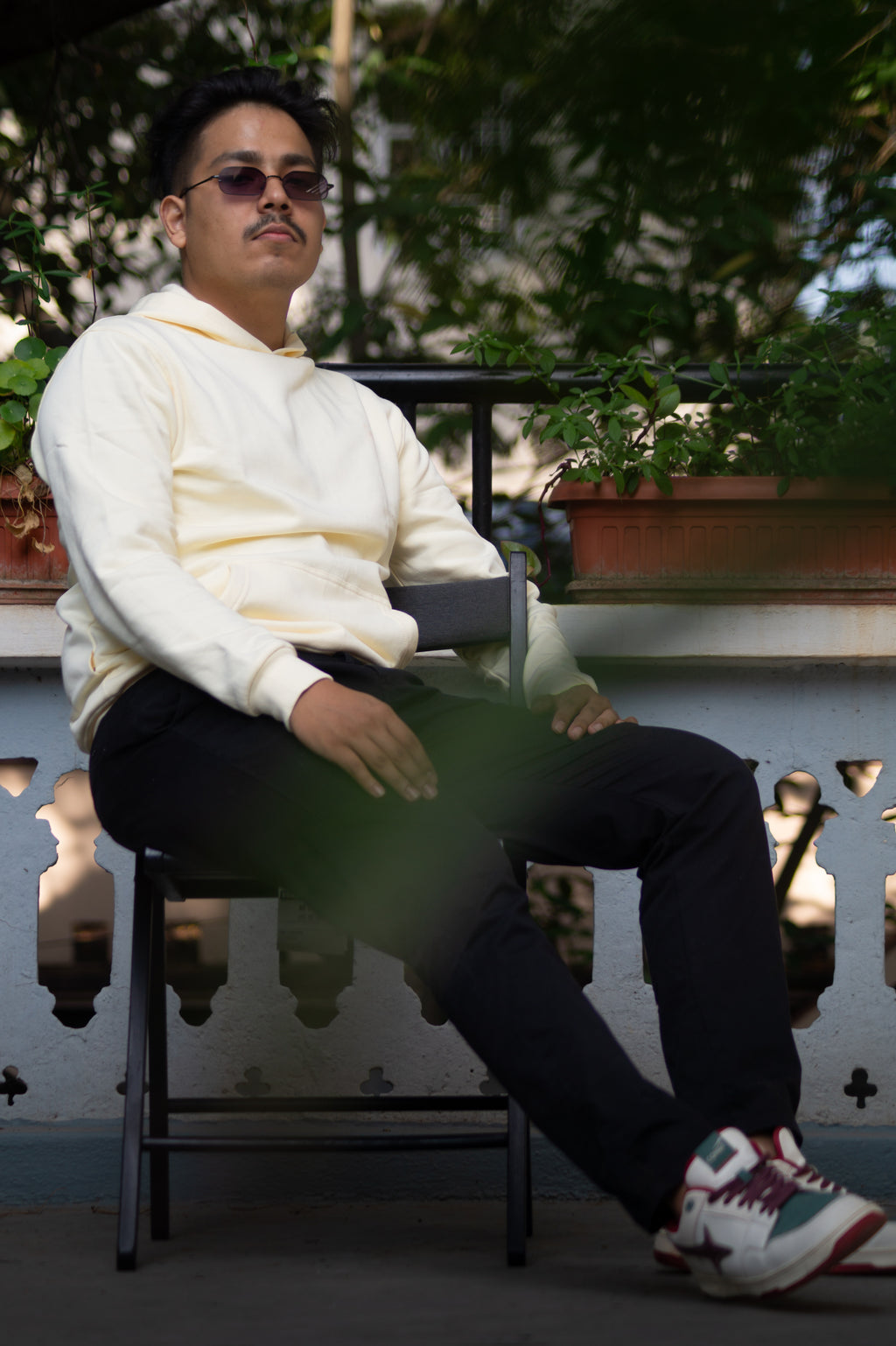 Man sitting on a chair with plants in the background