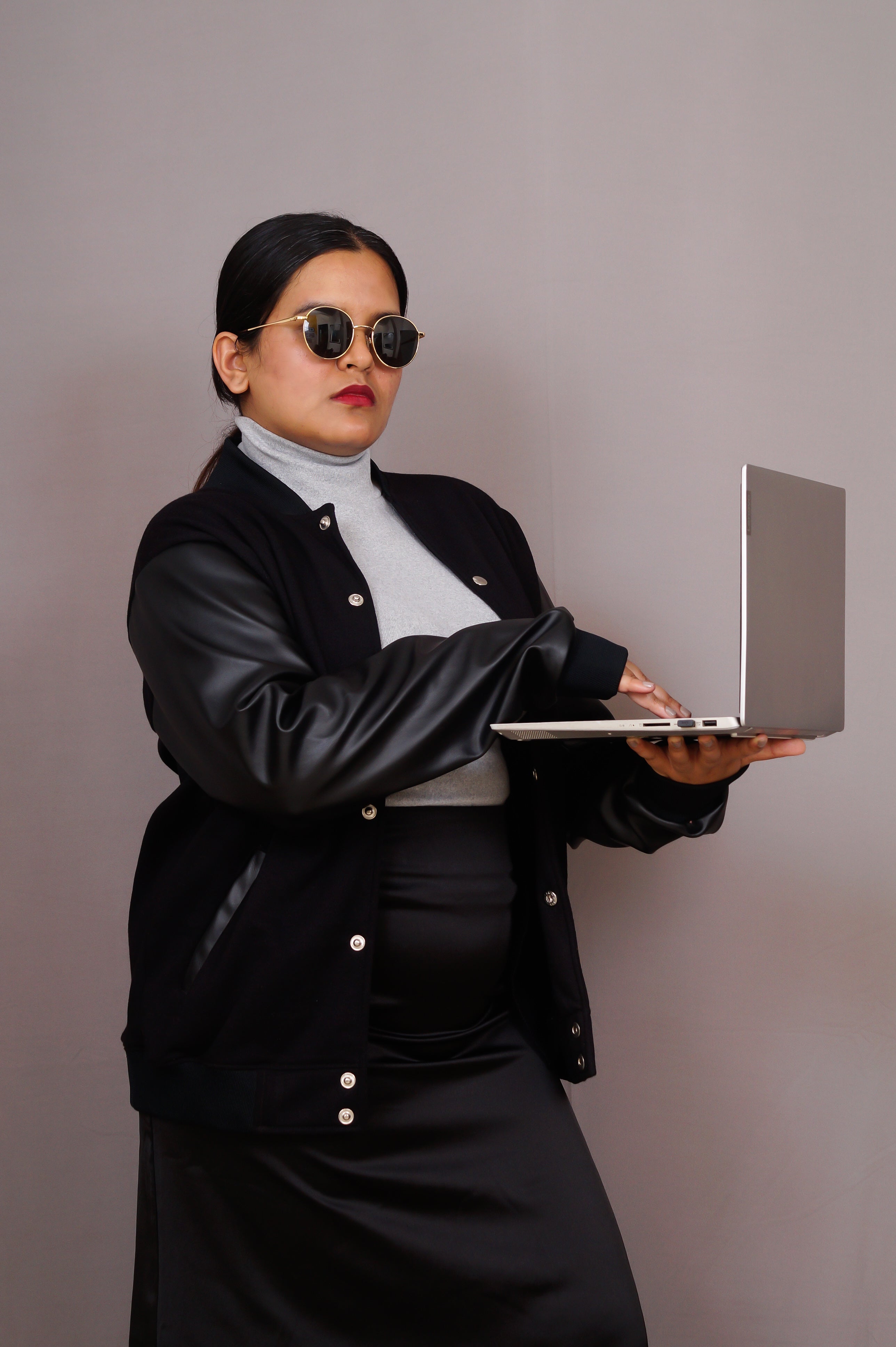 Person holding a laptop against a plain background