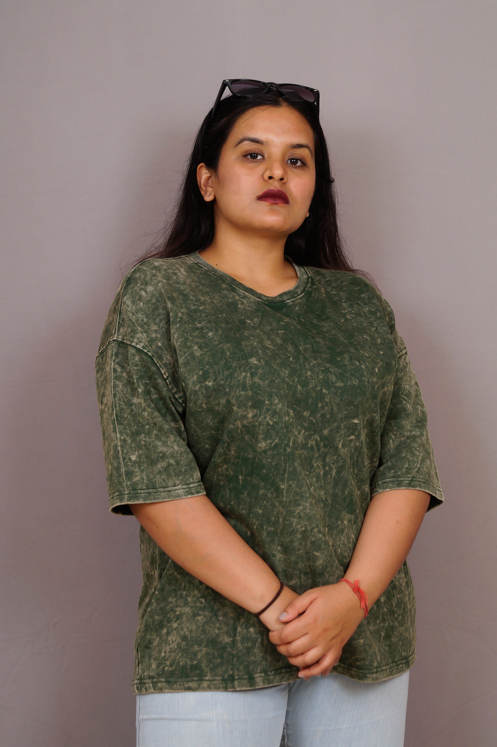 Woman wearing a green camouflage t-shirt against a plain background