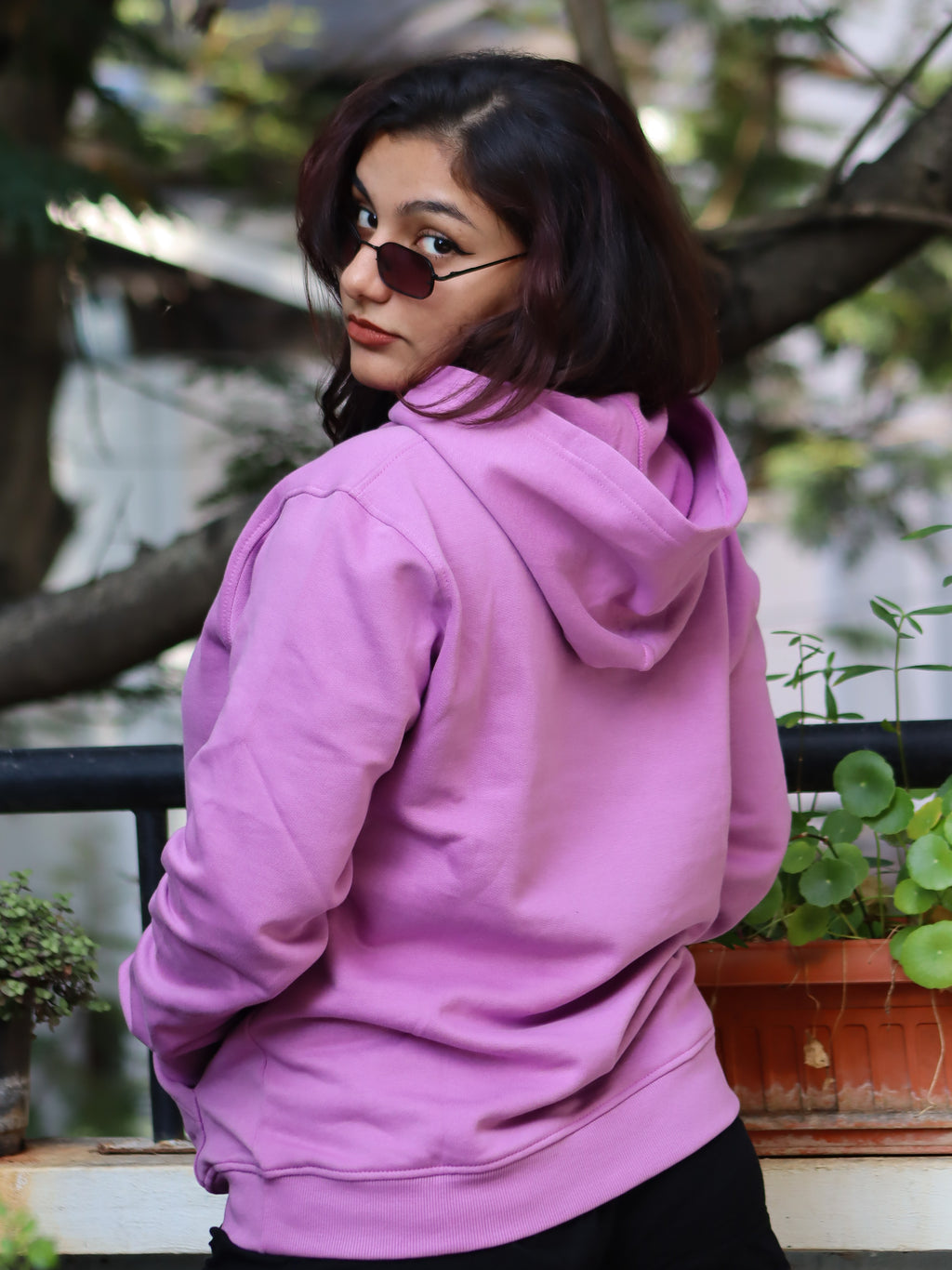 Person wearing a pink hoodie with a blurred background