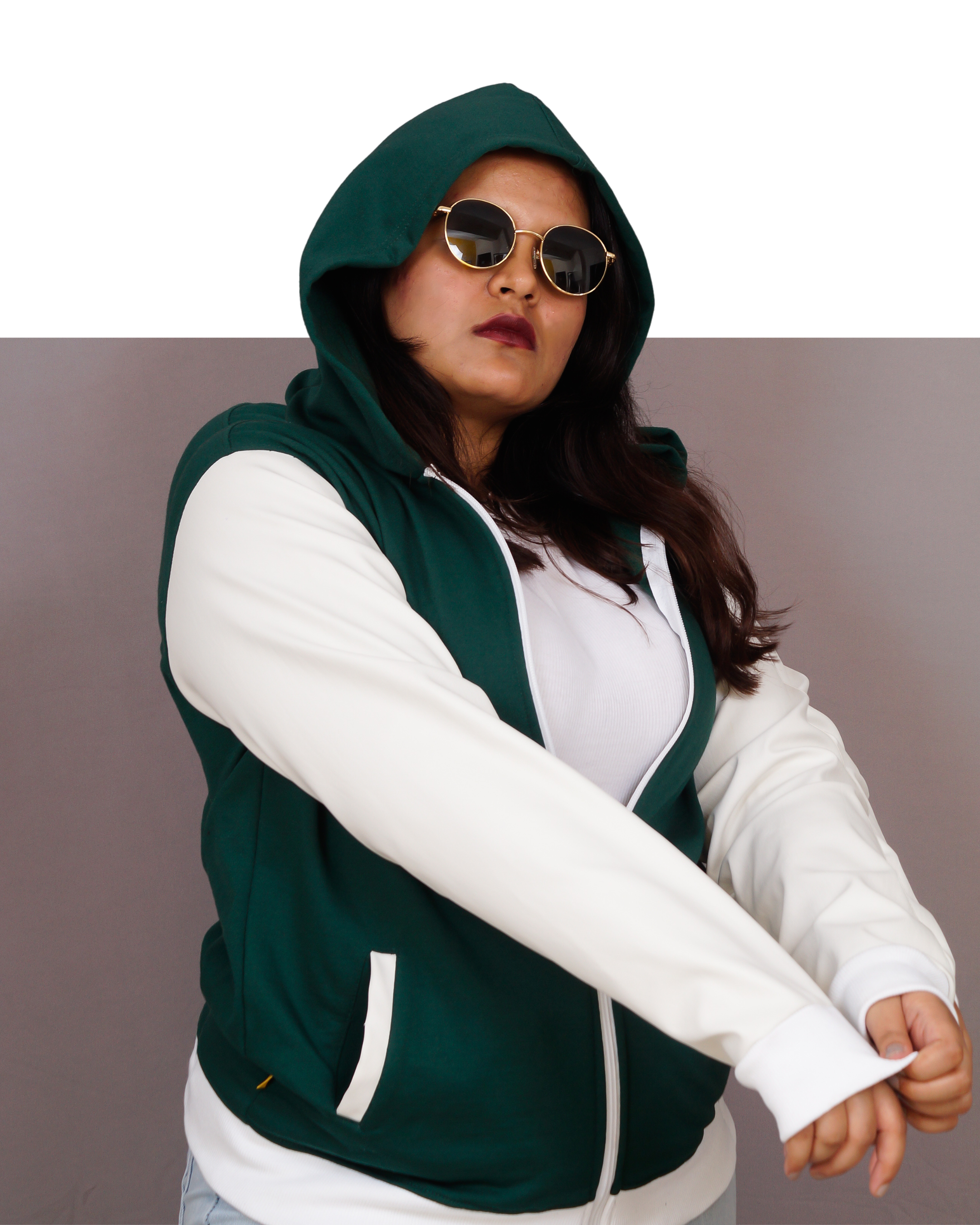 Person wearing a green and white varsity jacket with a plain background