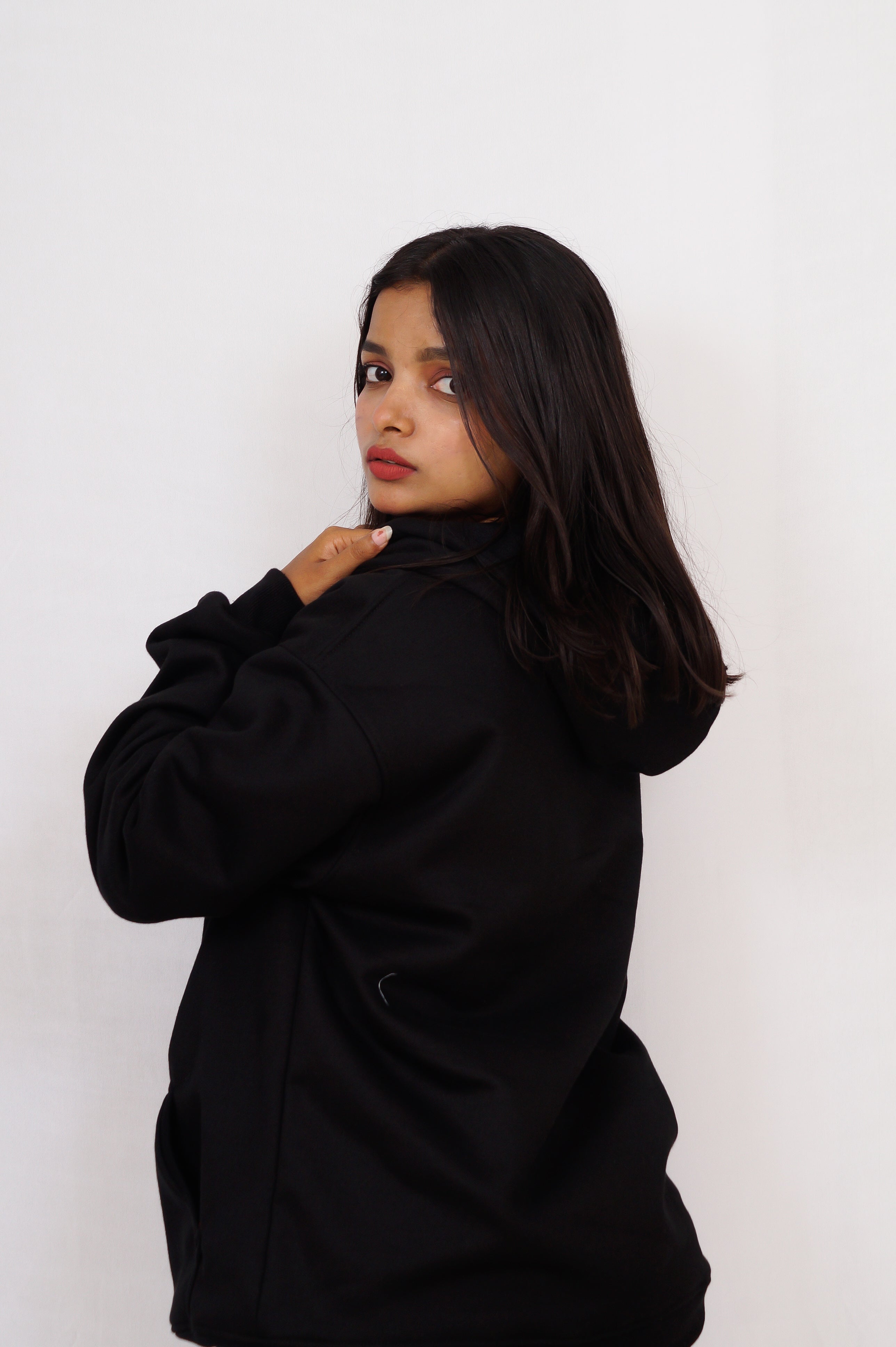 Woman wearing a black coat against a white background