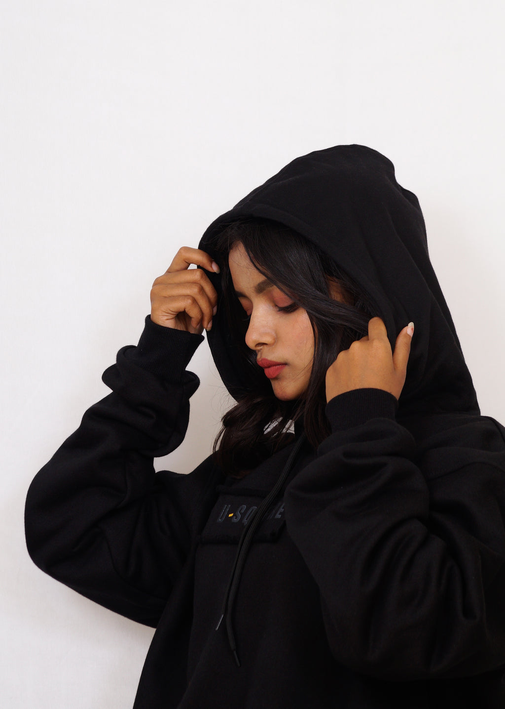 Person wearing a black hoodie against a white background