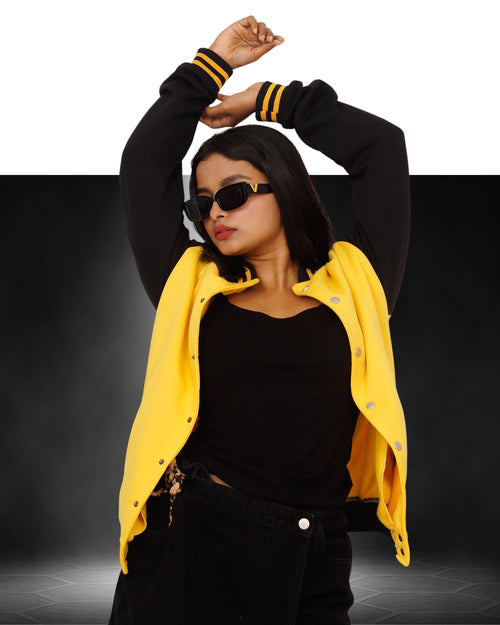 Person wearing a black outfit with a yellow varsity jacket on a dark background