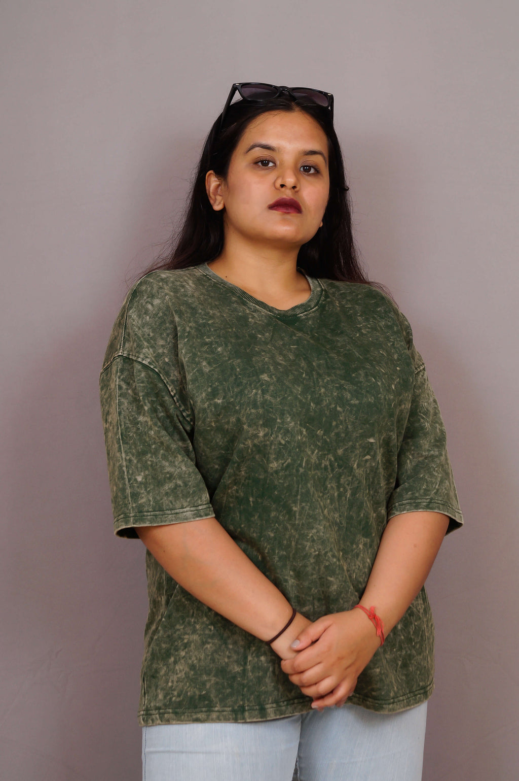 Woman wearing a green acid wash t-shirt against a plain background