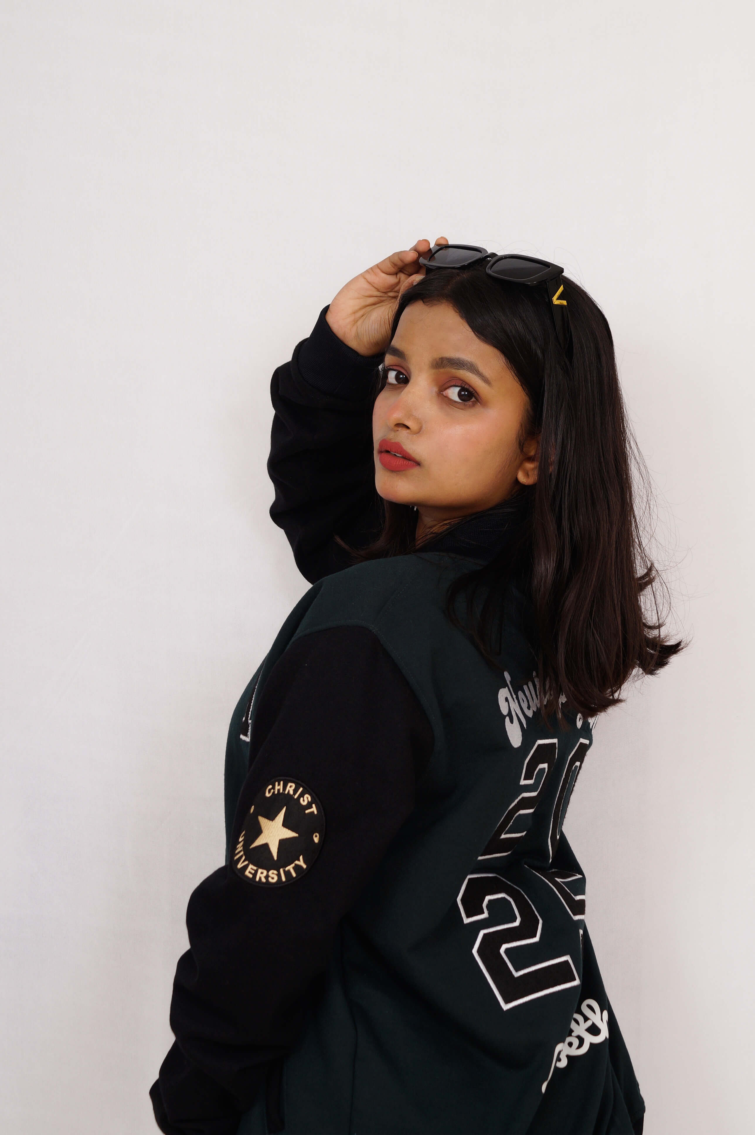Person wearing a black jacket with visible branding against a white background