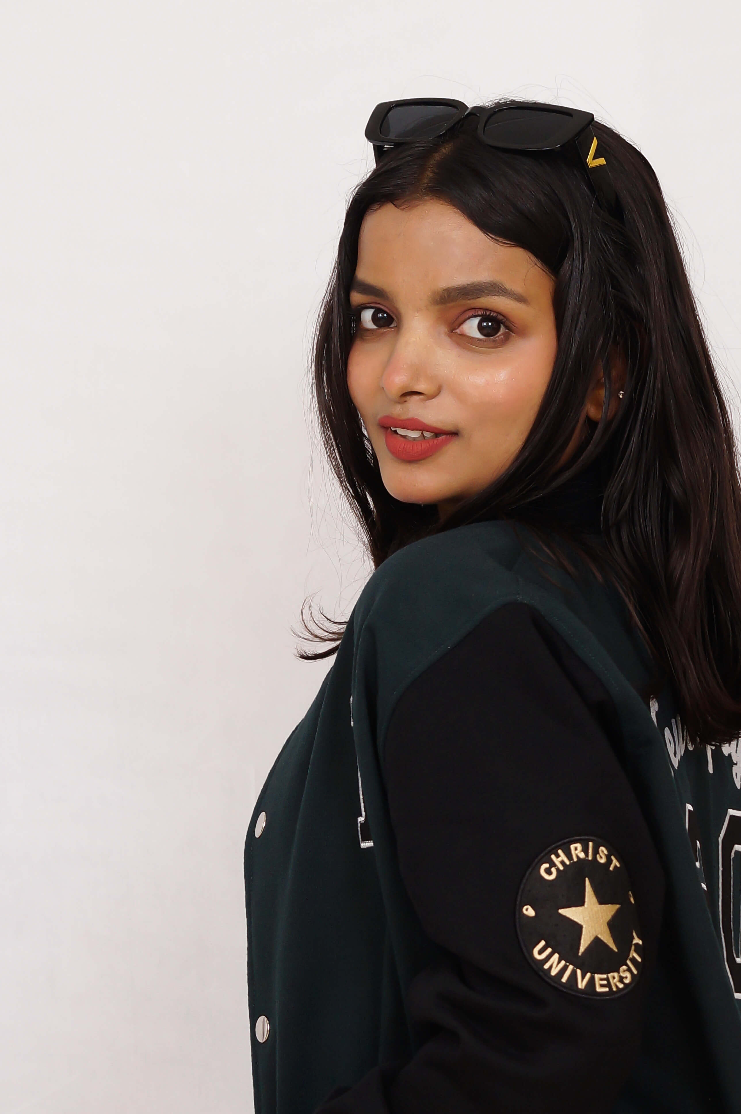 Woman wearing a black jacket with 'Christ University' logo on a white background