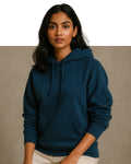 Woman wearing a blue hoodie against a beige background