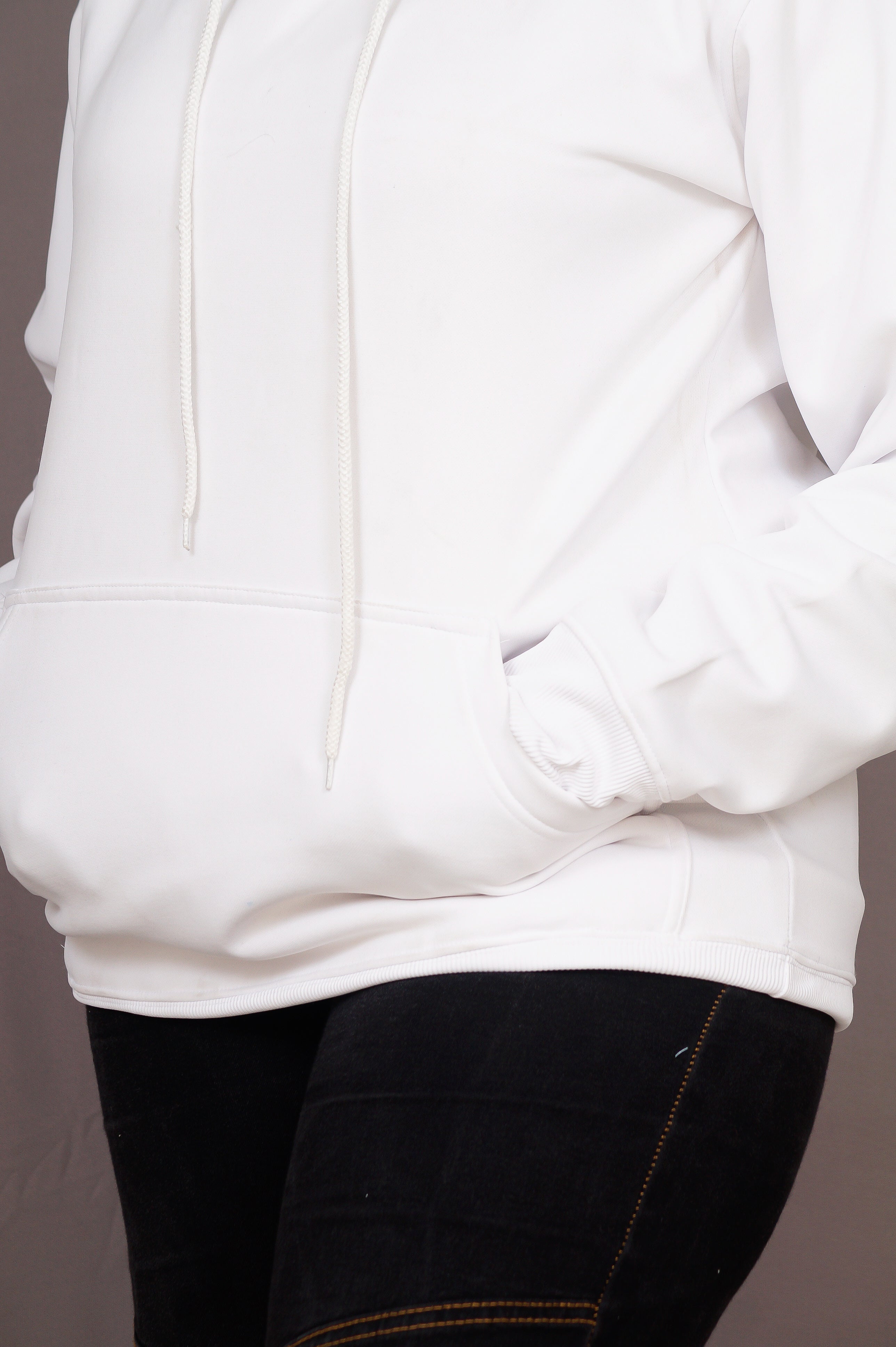 White hoodie with black pants on a neutral background